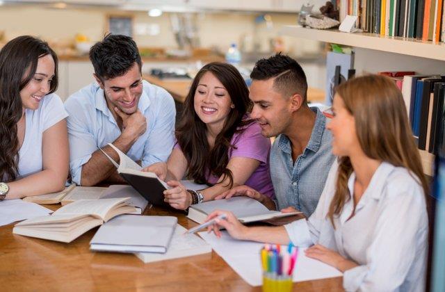 5 people studying together at a table